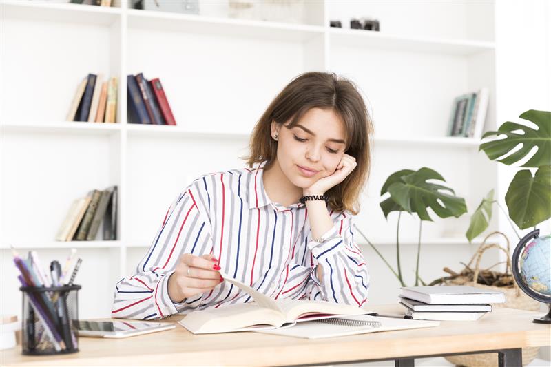 female-student-reading-wooden-desk